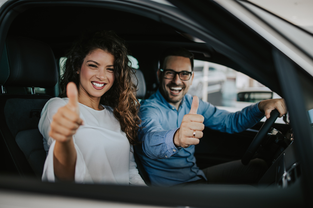Duas pessoas felizes dentro de um carro
