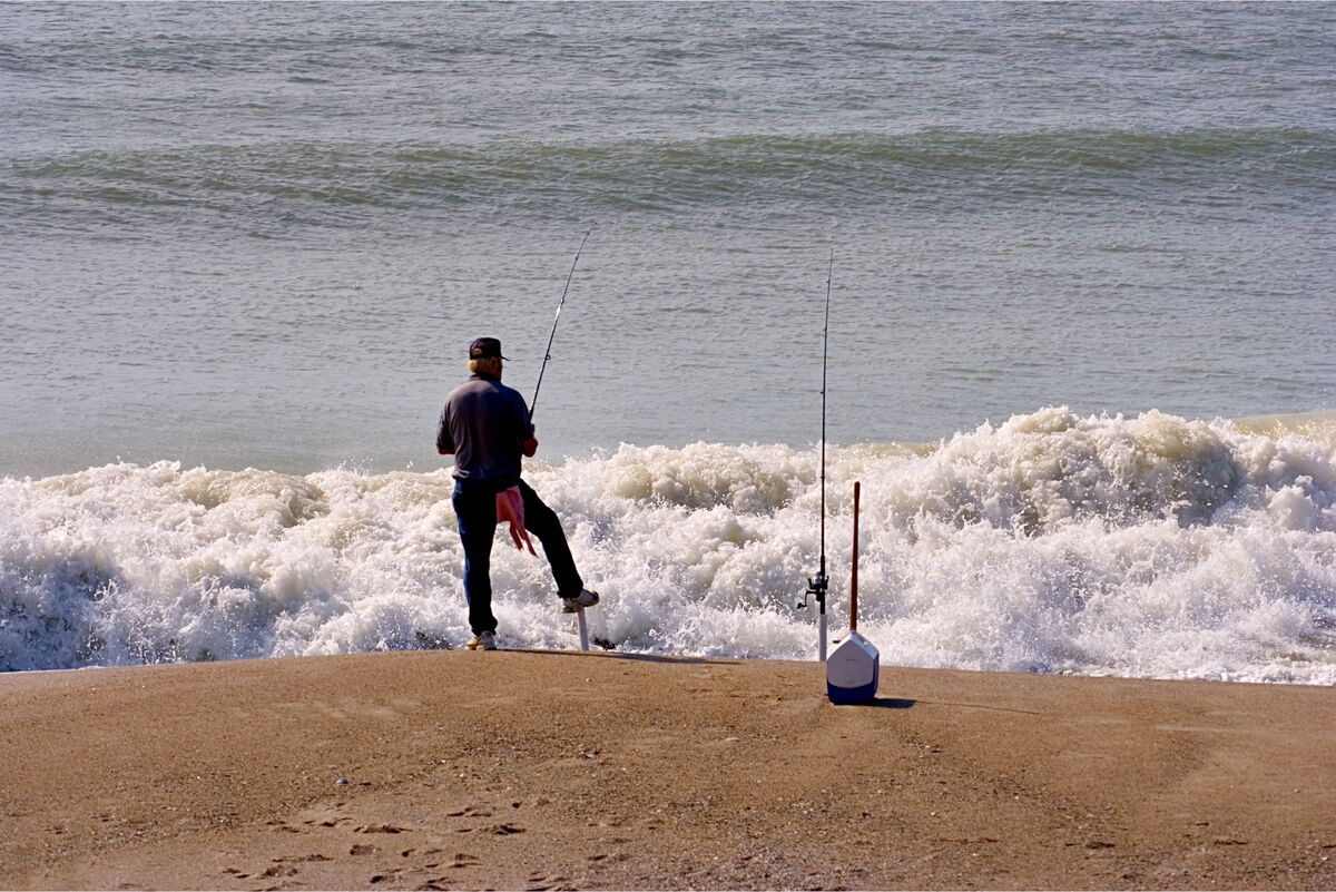 Homem pescando na praia 