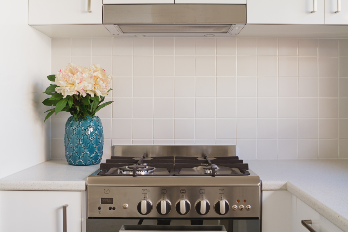 Close-up do forno de cozinha e azulejos na cor clara.