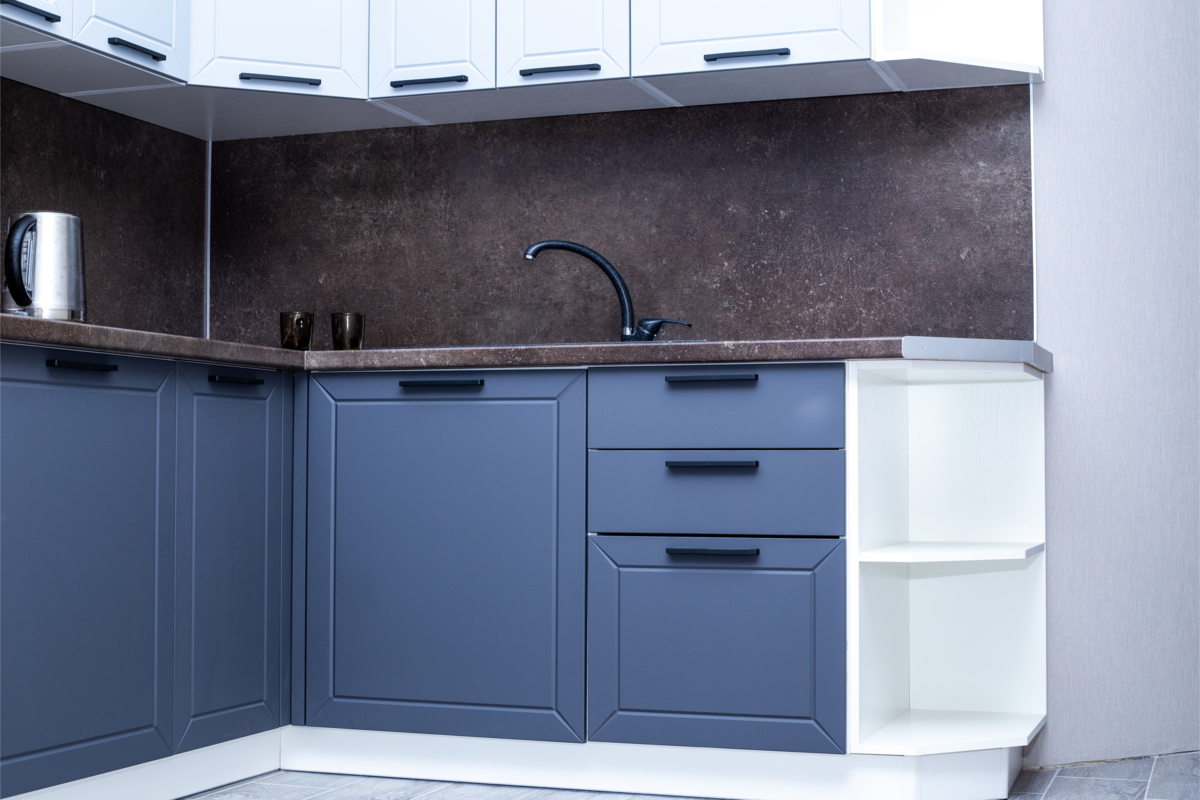 Cozinha com design industrial e móveis azuis.