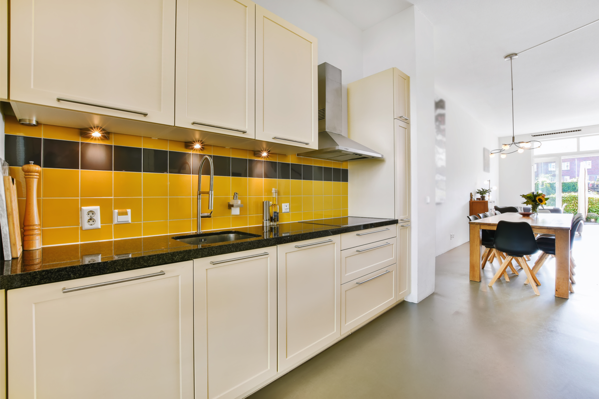 Cozinha moderna com azulejos na cor preta e amarela.