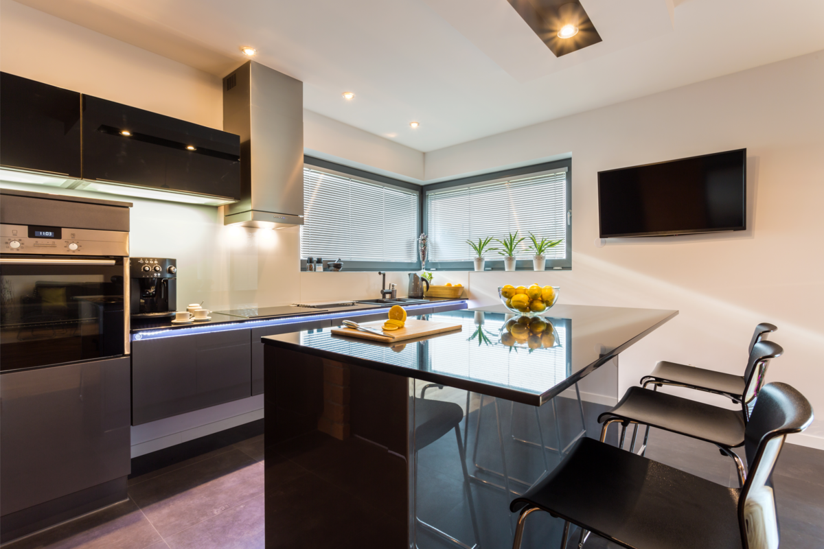 Cozinha com eletrodomésticos embutidos na cor preta e parede branca.