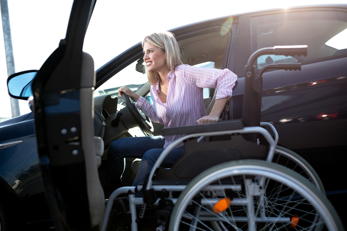 Pessoa com deficiência física em carro adaptado 