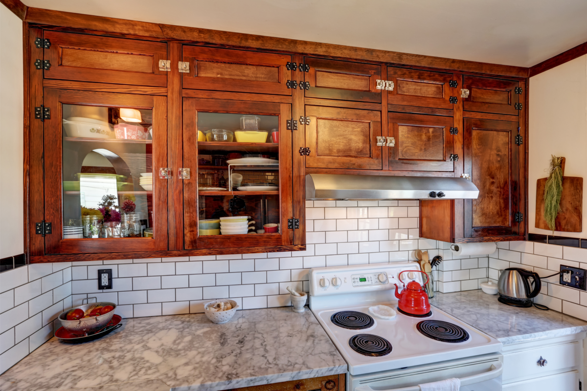 Cozinha vintage com armário embutido na parede de madeira.