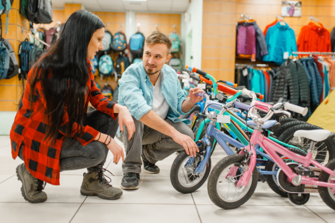 Indivíduos escolhendo uma bicicleta infantil na loja