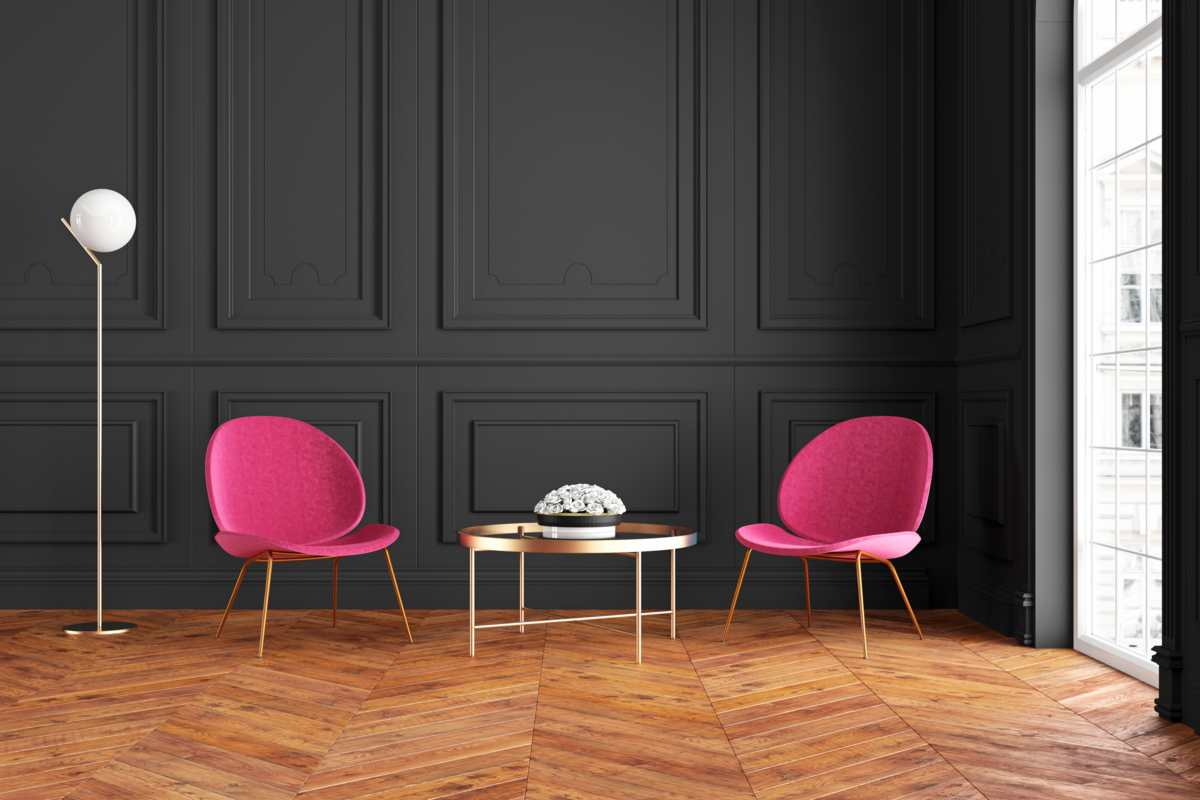 Ambiente moderno com cadeiras rosas e parede escura.
