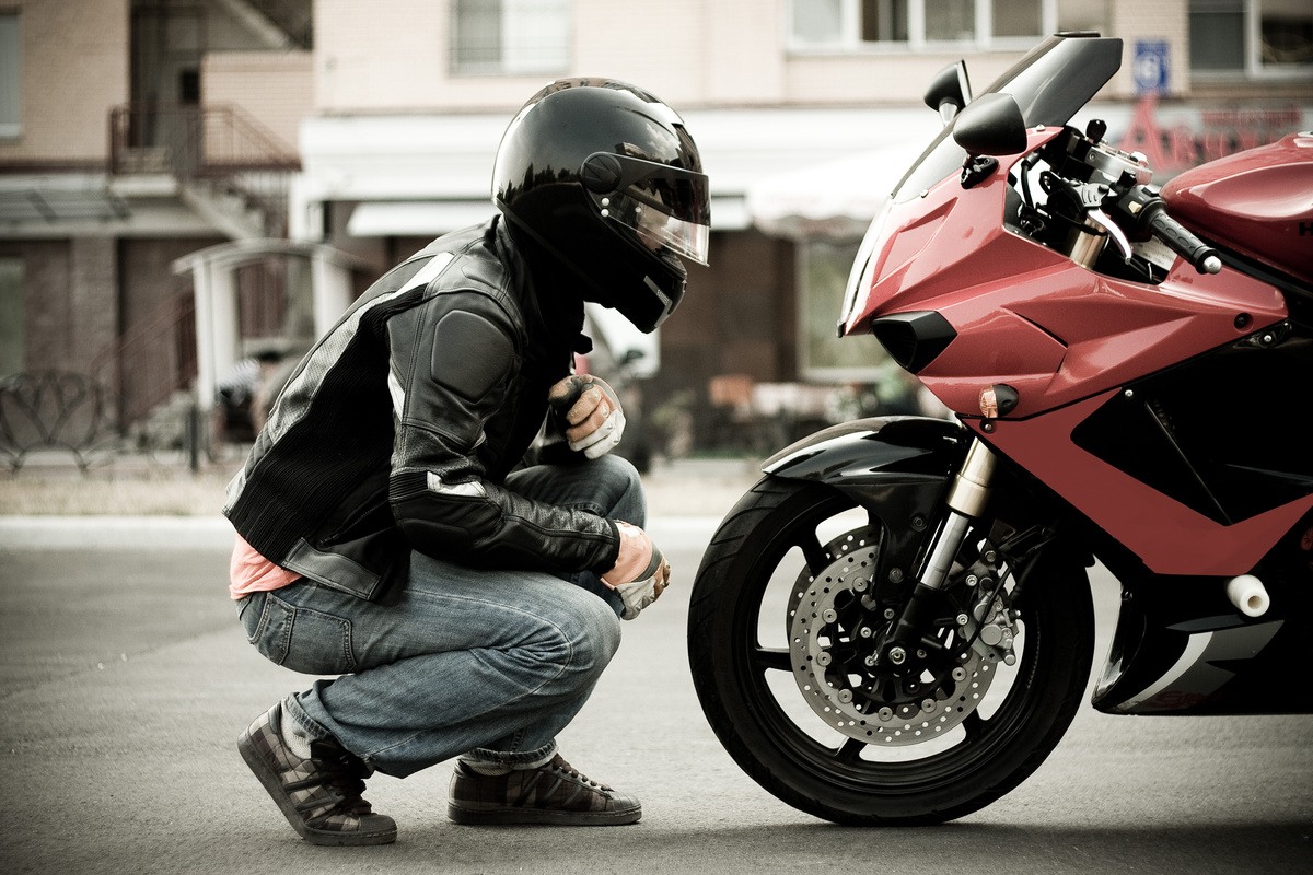 Homem olhando para moto