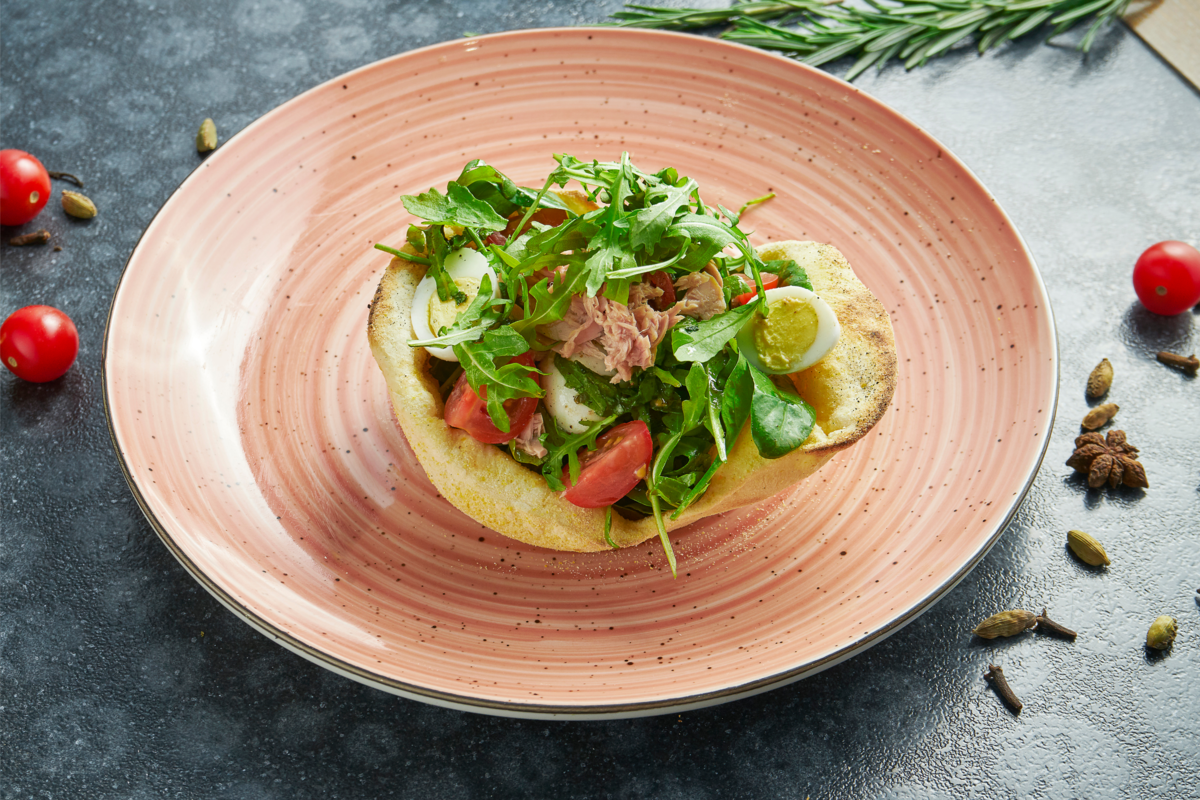Salada de atum com pita em um lindo prato de cerâmica.