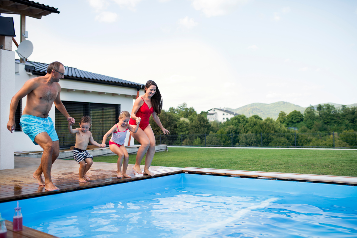 Família pulando na piscina 