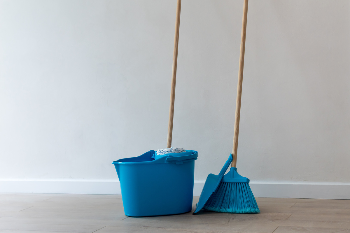 Vassoura azul e outros equipamentos de limpeza 