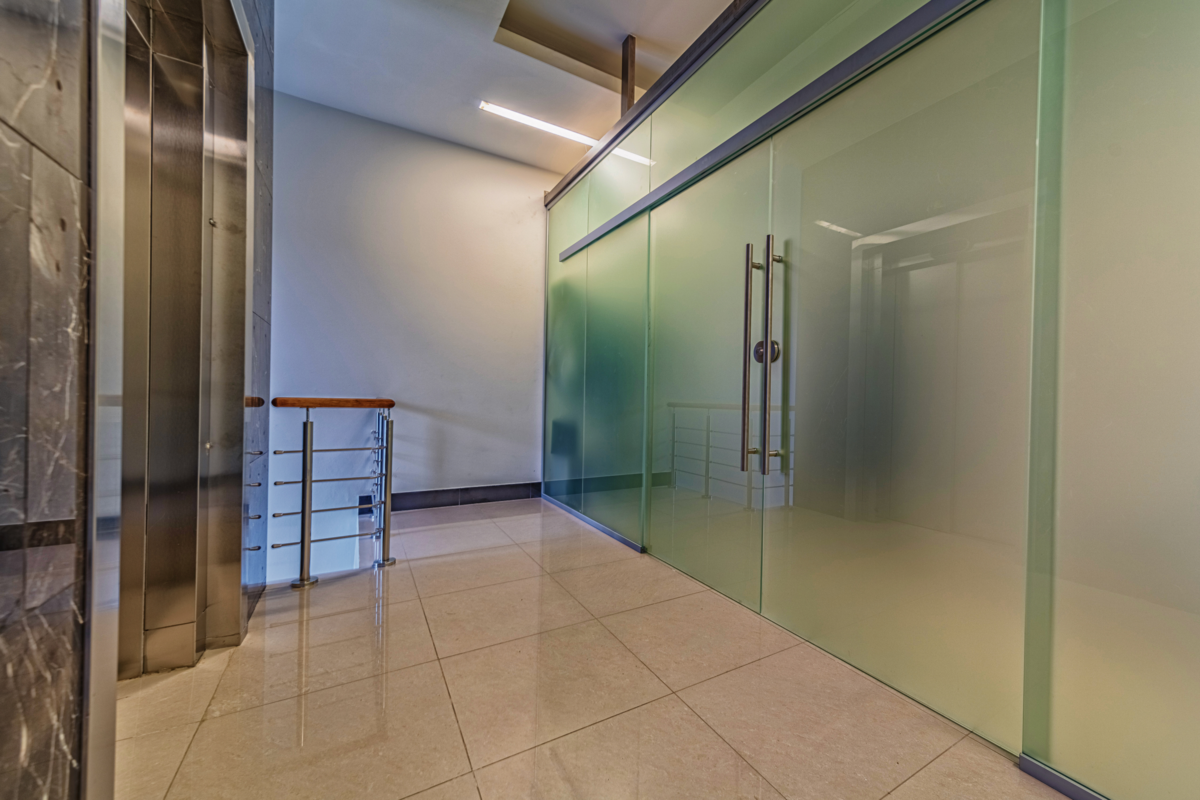 Portas de vidro fosco moderno, na entrada perto do elevador.