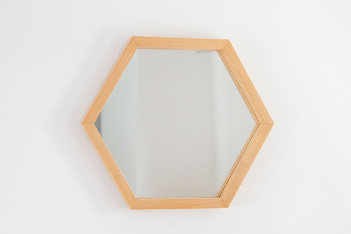 Espelho em formato hexagonal com moldura de madeira clara