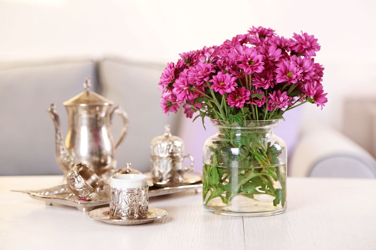 Mesa com vaso de flores e jogo de chá