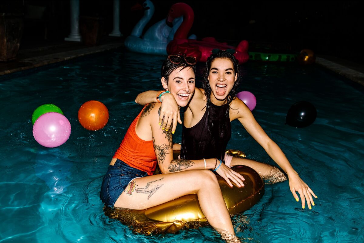 Duas mulheres em pool party à noite