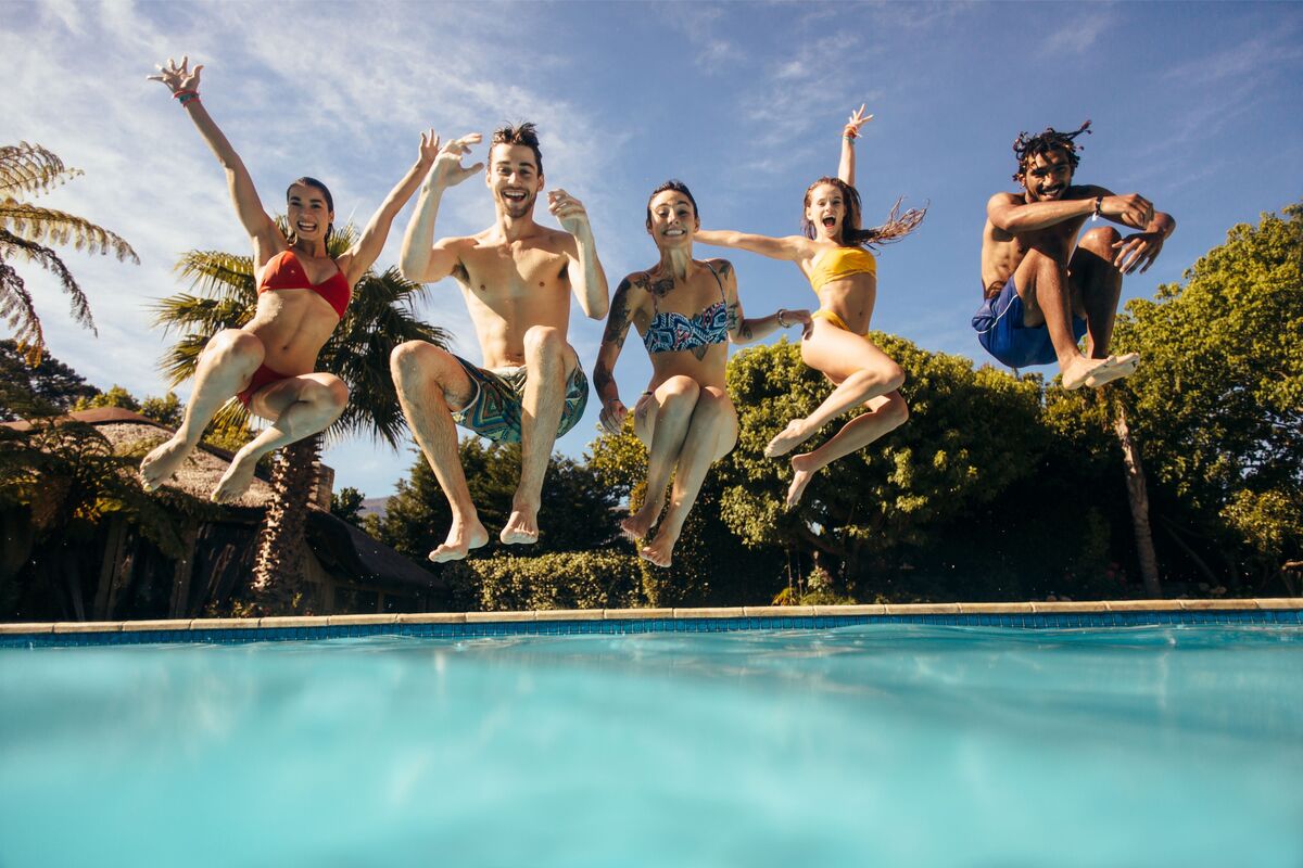 Cinco amigos pulando na piscina
