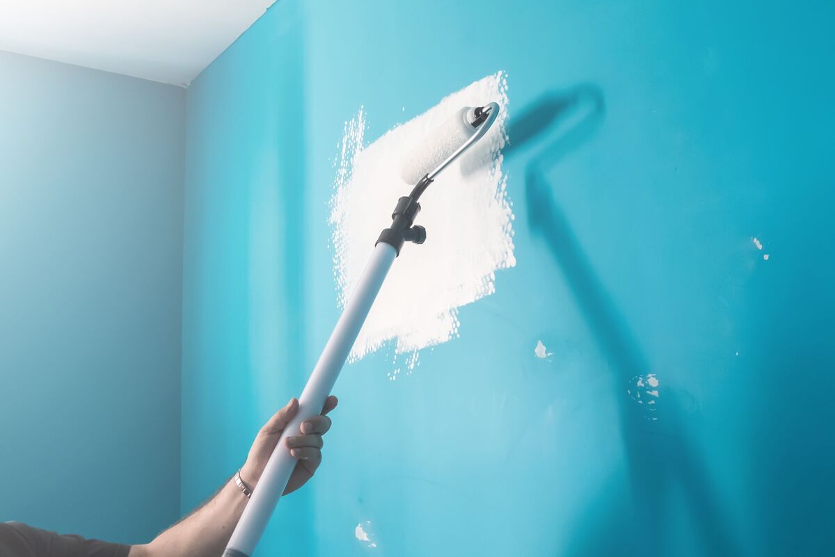 Pessoa pintando uma parede azul
