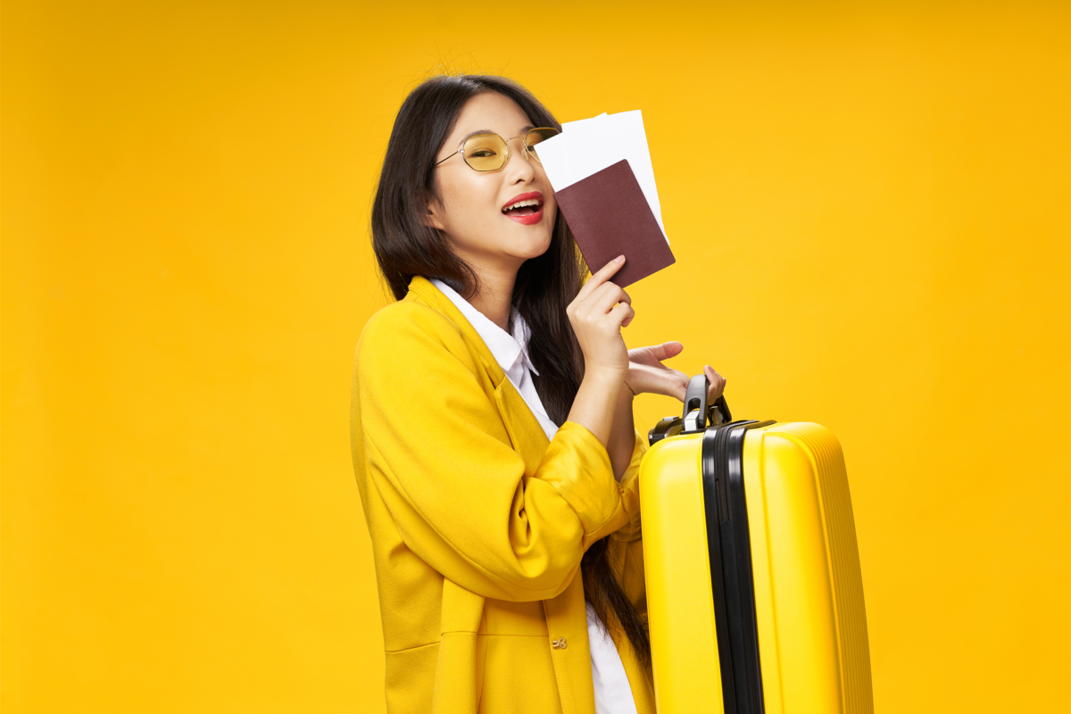 Mulher com passaporte, bilhete de avião e mala