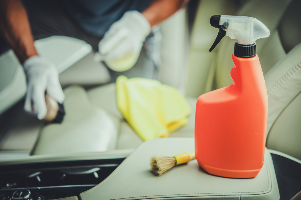 Homem limpando o interior de veículos com detergente higienizante