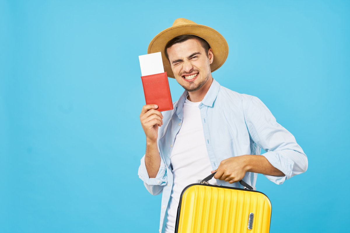 Homem de chapéu com passaporte e mala em um fundo azul.