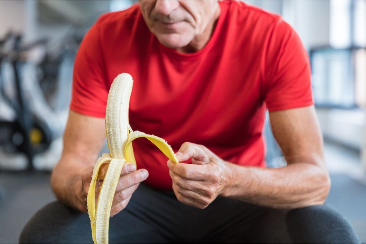 Senhor comendo banana no pós-treino