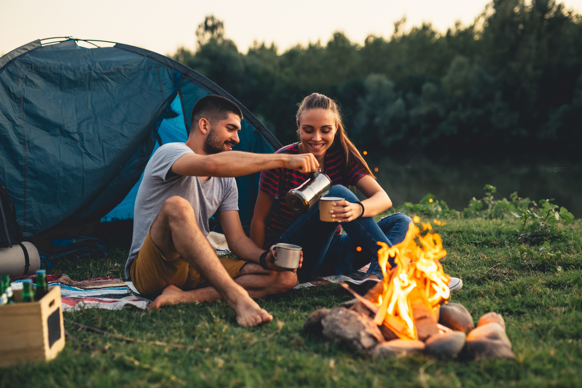 Um casal tomando café no acampamento