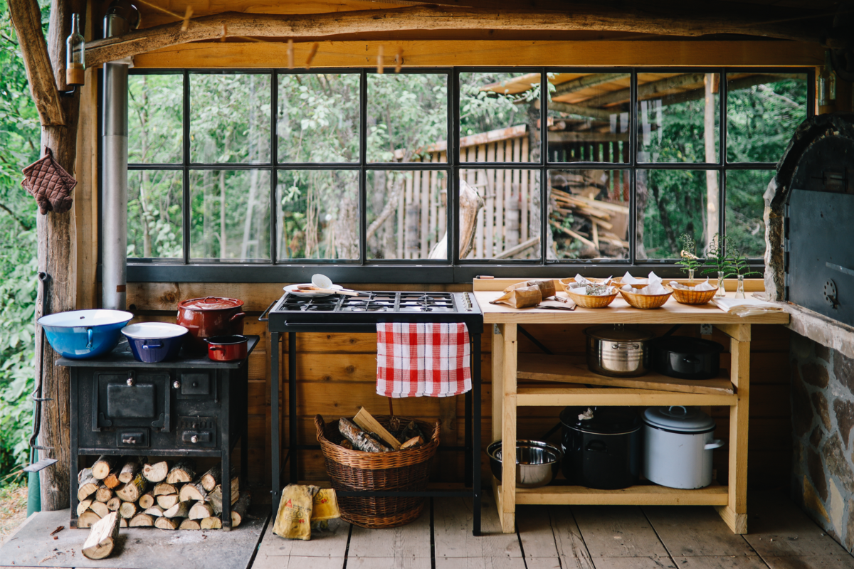Cozinha externa de madeira e com forno a lenha bem rústico.
