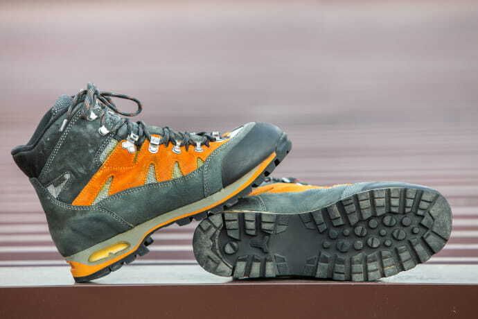 Um par de botas bota de trekking de cor cinza e laranja 