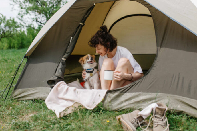 Uma mulher com seu cachorro dentro da barraca 