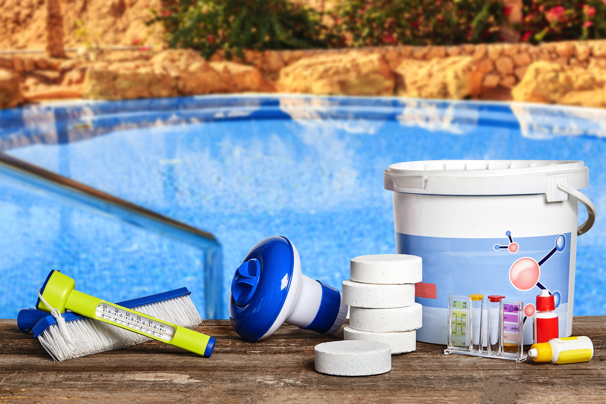 Equipamentos com produtos químicos de limpeza e ferramentas para a manutenção da piscina