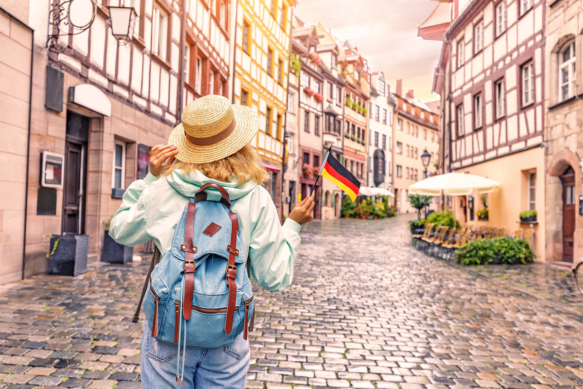Jovem turista viajando com bandeira alemã na cidade de Nuremberg