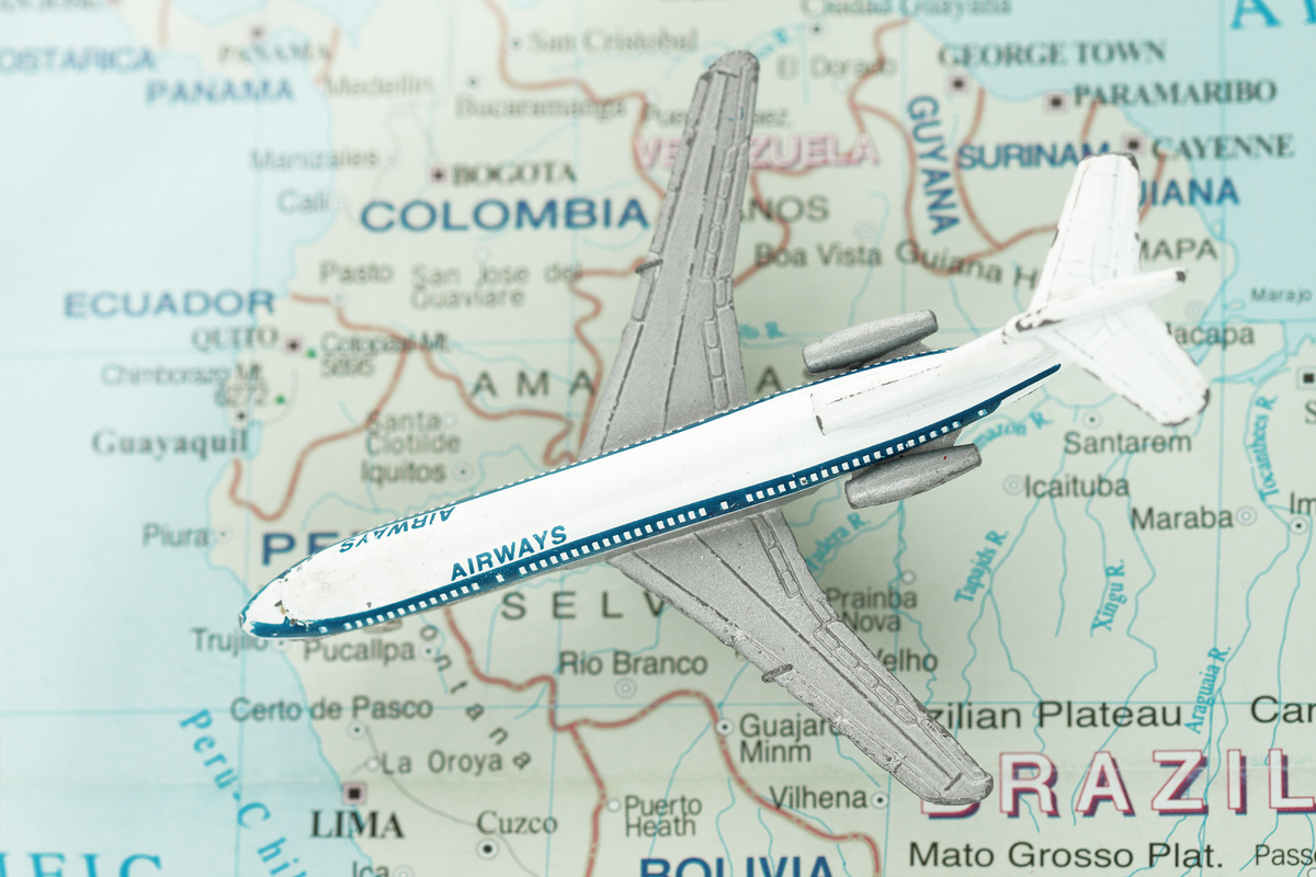 Avião de brinquedo sobre mapas do Brasil e Peru