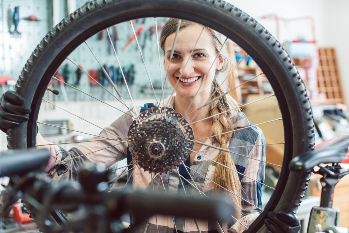 Uma mulher olhando através da roda de uma bicicleta