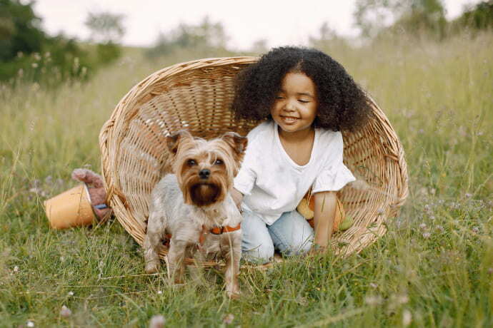 Uma criança e um cachorro ao ar livre