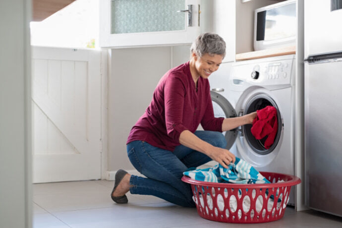 Mulher colocando roupas na secadora 