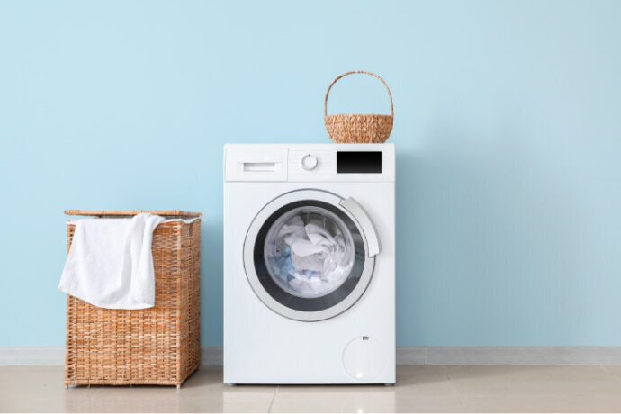 Secadora de roupas e um cesto de palha na lavanderia