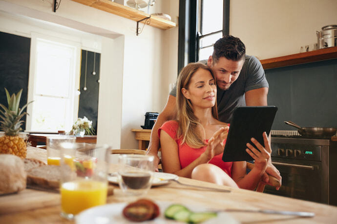 Um casal na cozinha mexendo no e-reader