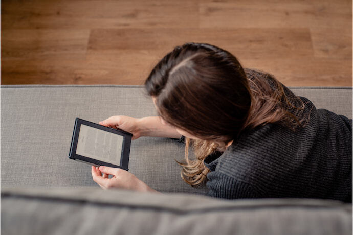 Uma mulher lendo o e-reader na sala 
