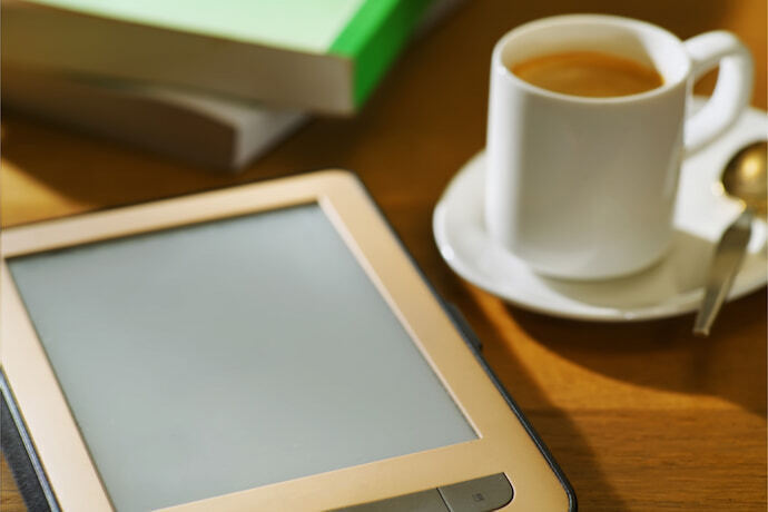 Um e-reader com um copo de café ao lado