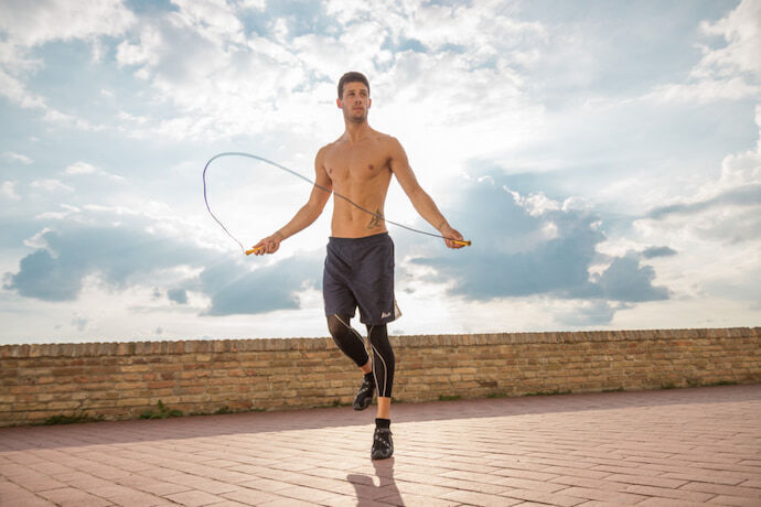 Homem fazendo exercícios com corda de pular.
