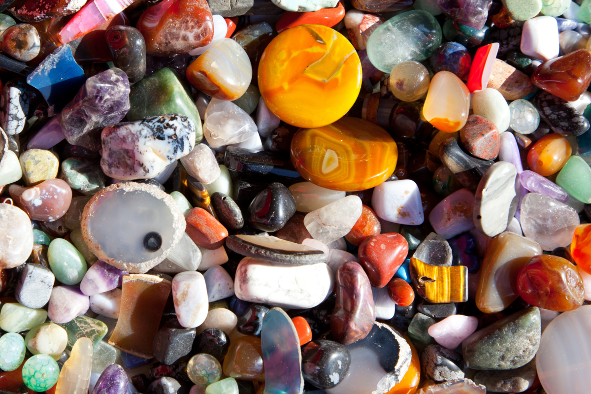 Vista de perto várias pedras do tipo ágata multicoloridos.