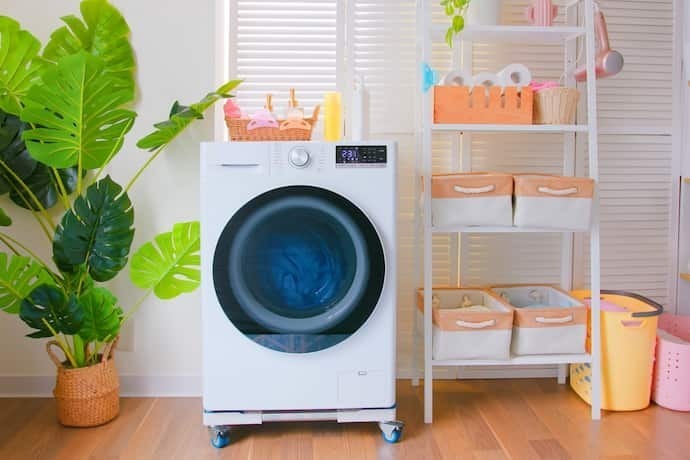 Uma máquina de lavar de cor branca na lavanderia.