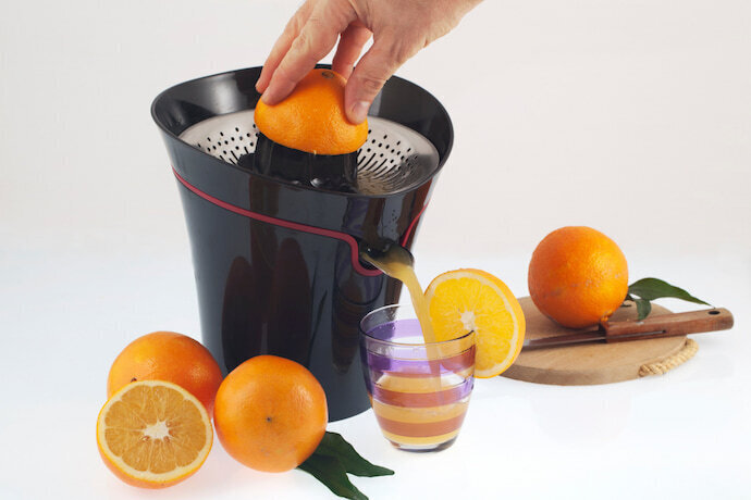 Alguém espremendo laranja em um espremedor de frutas e um fundo branco