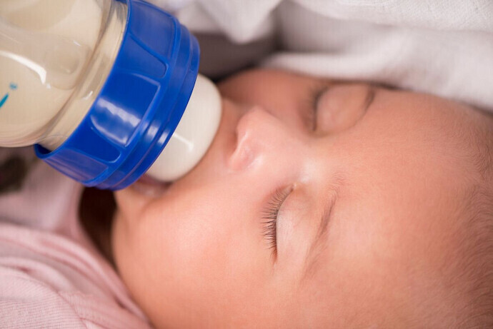 Bebê tomando leite em mamadeira 