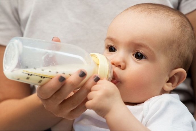 Bebê saudável bebendo leite em mamadeira 