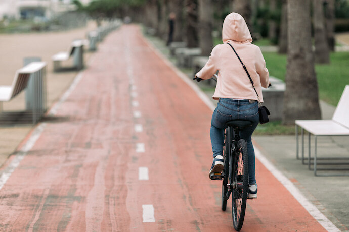 Mulher na cidade andando de bicicleta na faixa 