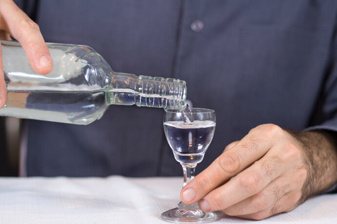 Homem colocando vodka no copo