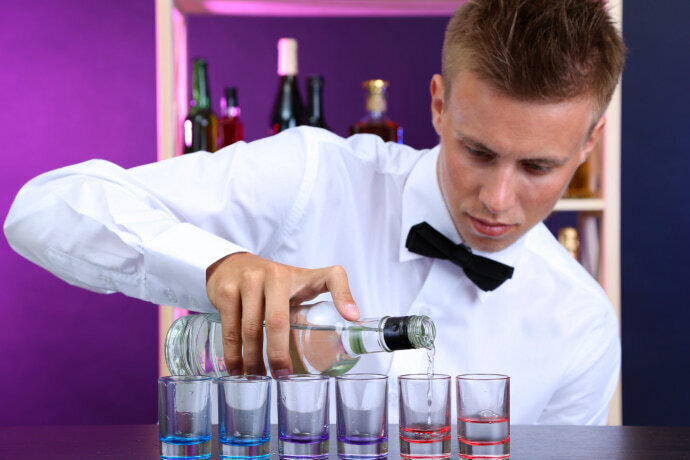 Homem colocando vodka no copo