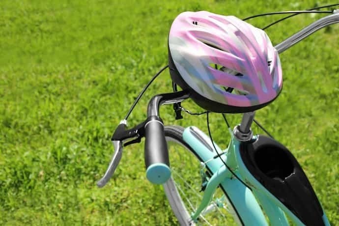 Haste e capacete de bicicleta em fundo de grama verde