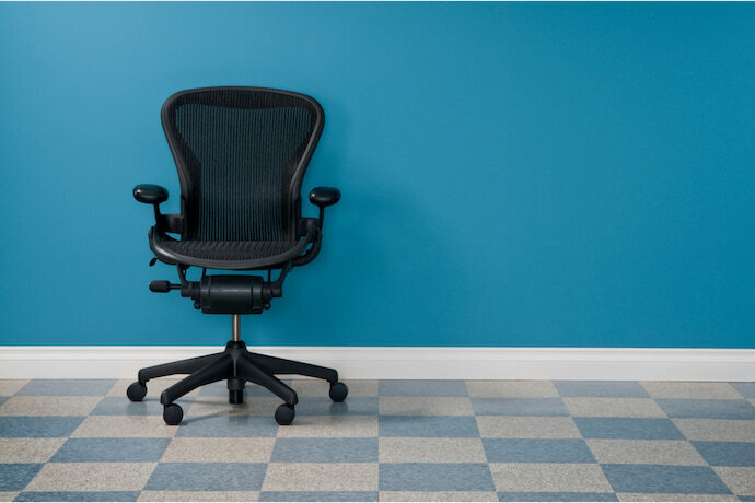 Cadeira de escritório de cor preta em um cômodo azul.