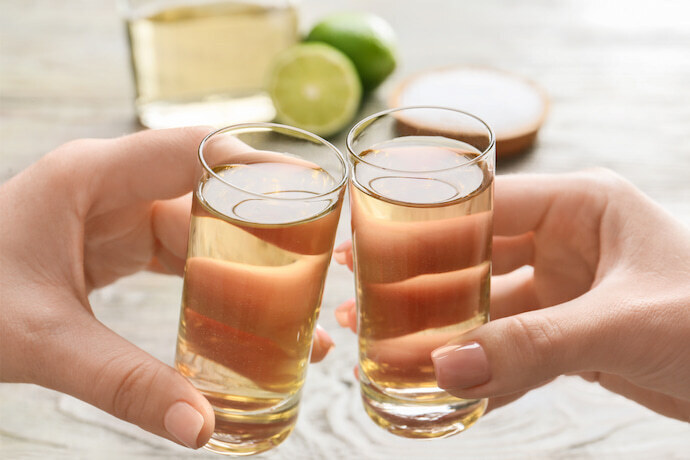 Close-up de mulheres bebendo tequila na mesa.
